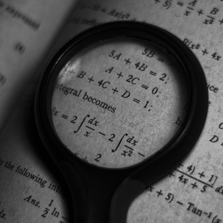 Magnifying glass sitting on page with equations